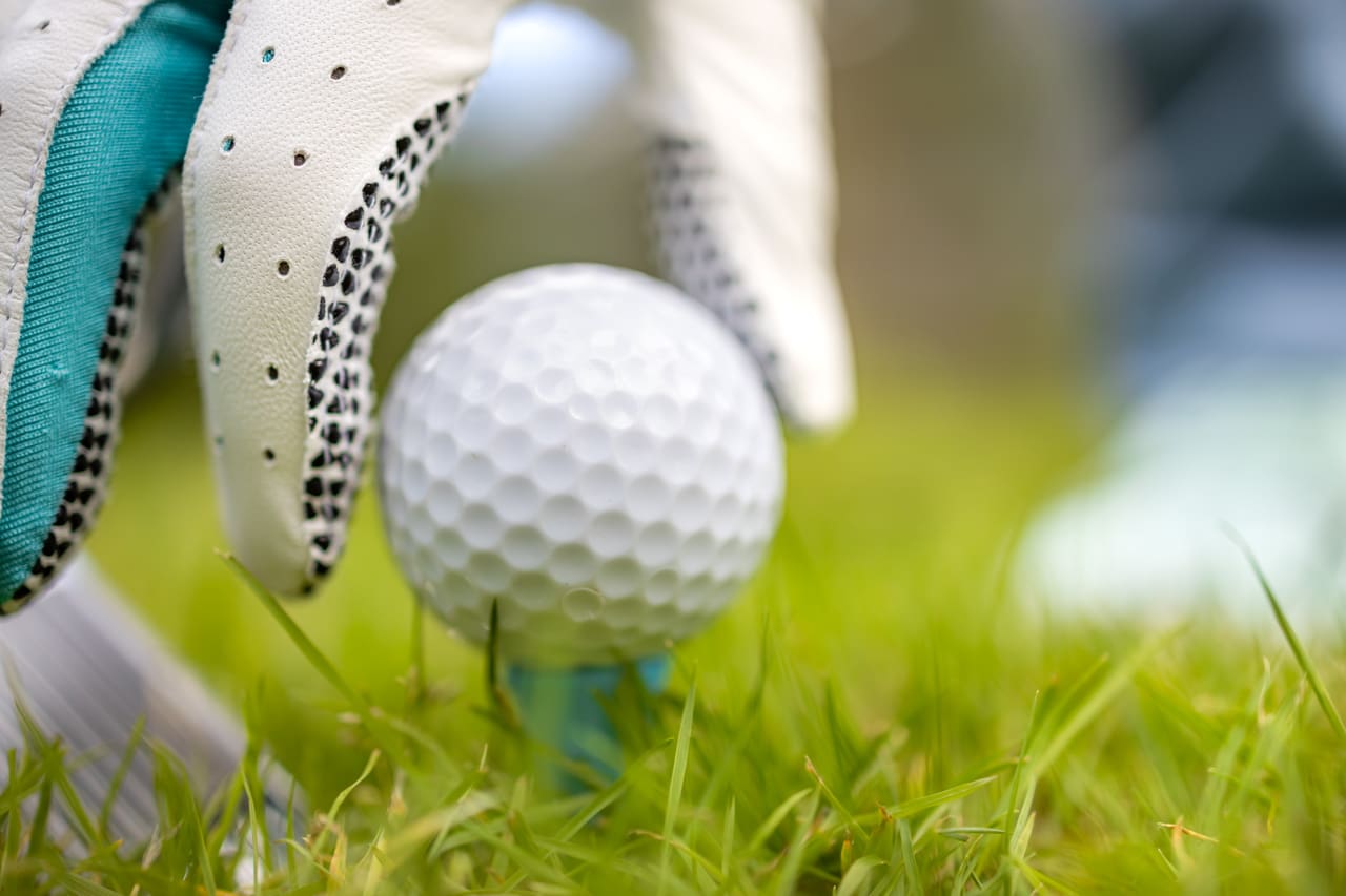 Hand in glove placing ball on tee Salida Golf Club collegiate peaks views golf in the colorado rockies Hand in glove placing ball on tee Salida Golf Club collegiate peaks views golf in the colorado rockies